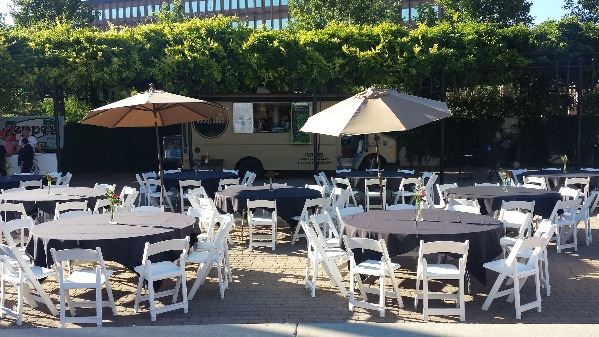 Lucky Slice Pizza truck and round tables linens and with chairs in the Amp plaza